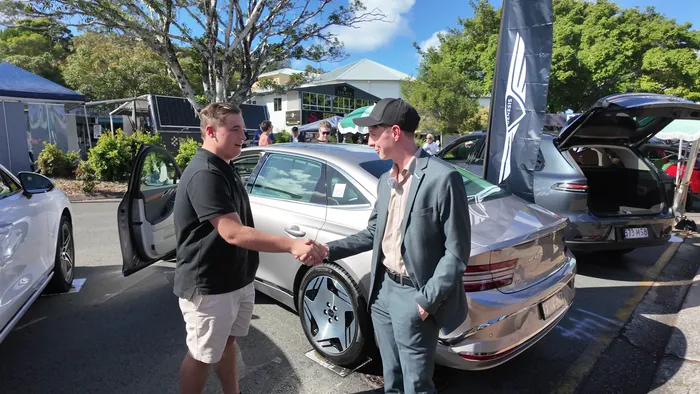Adam shaking hands with a Genesis representative at the Noosa EV Expo